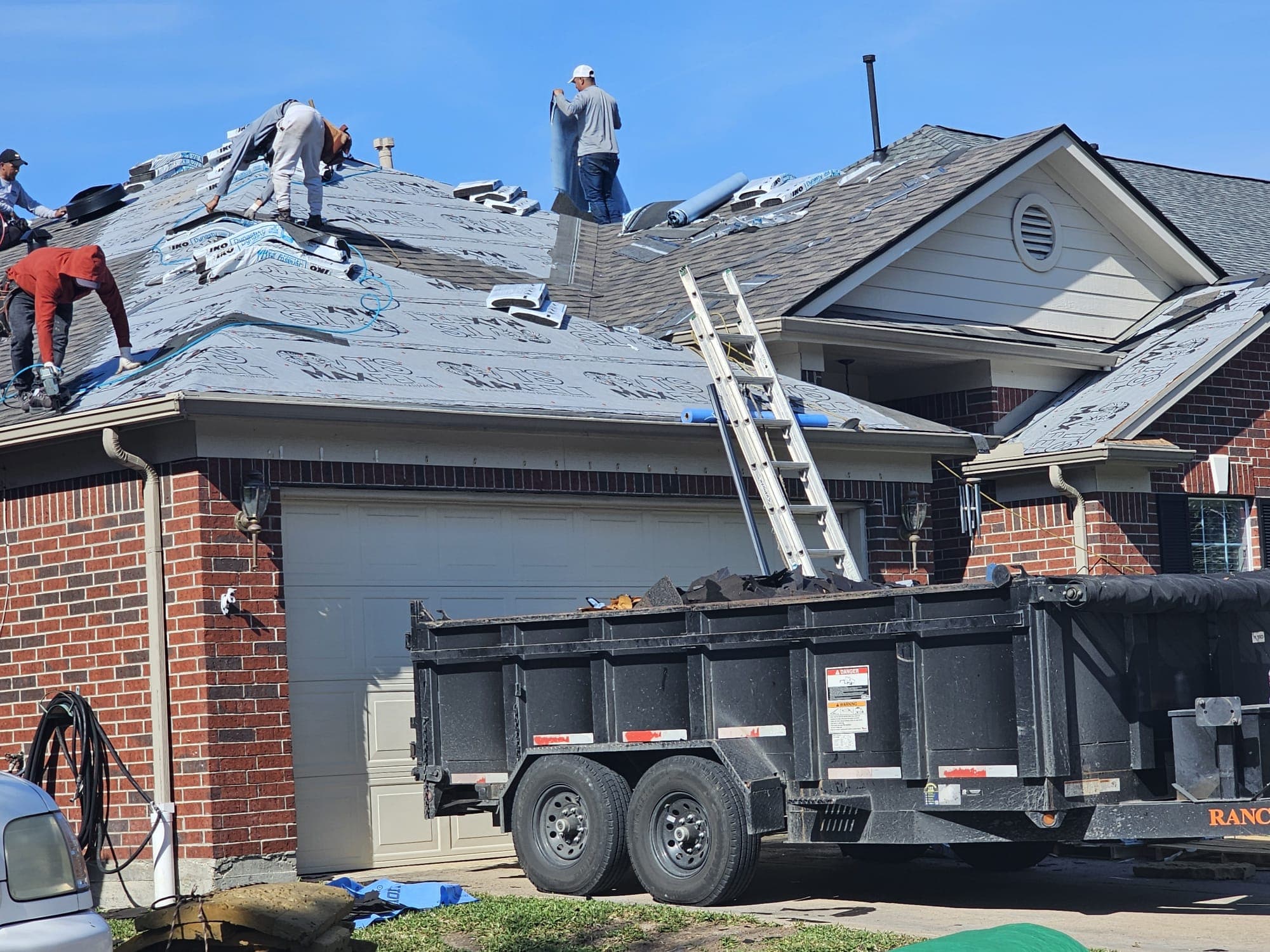 Jerrys Roofing crew actively installing a new roof on a brick home in Katy, Texas